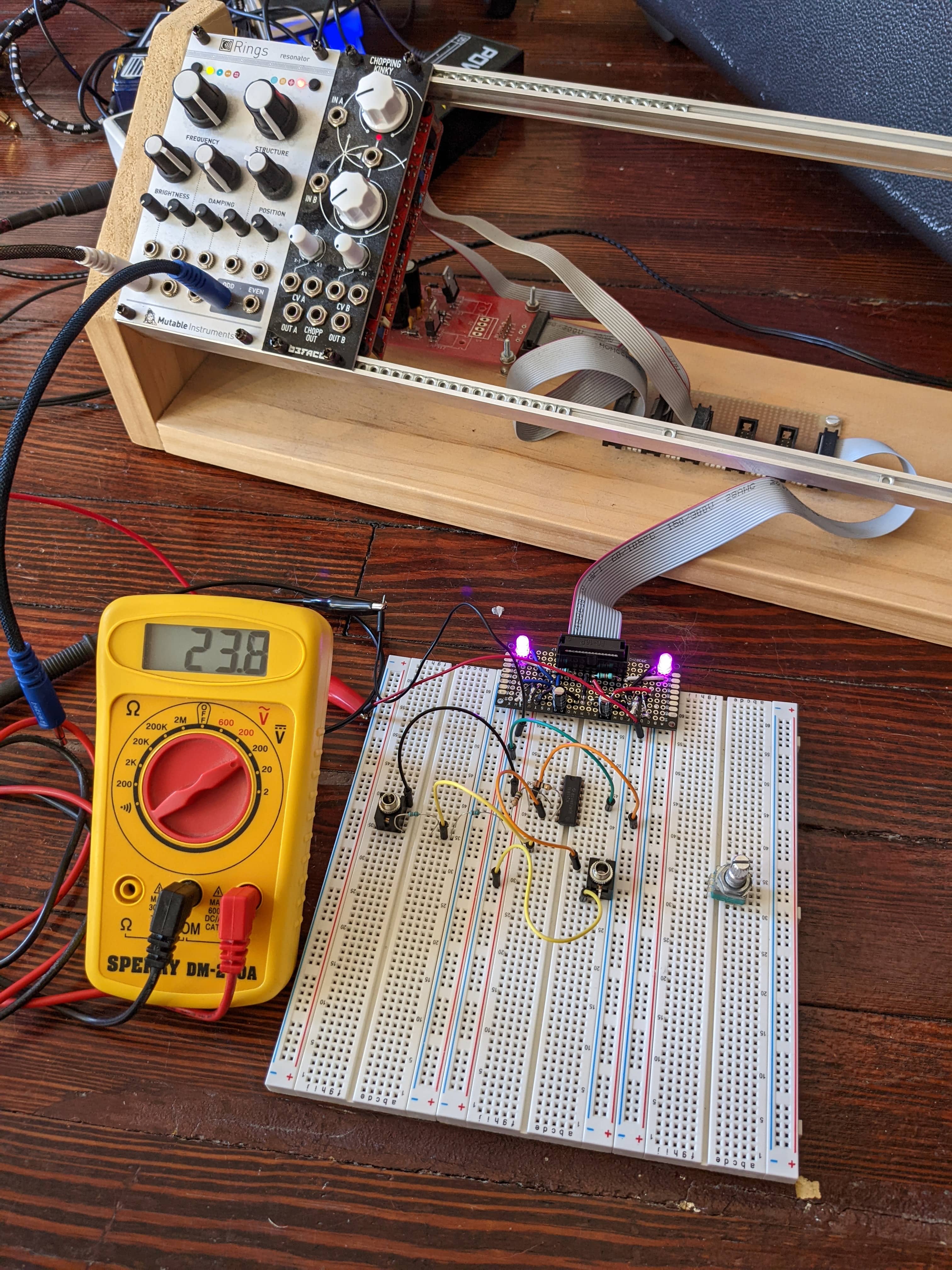 The Eurorack Breadboard Power module connected to a volt meter showing 23.8 volts